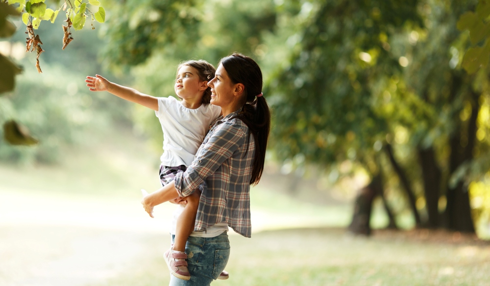 Mother and daughter playing and running around the park