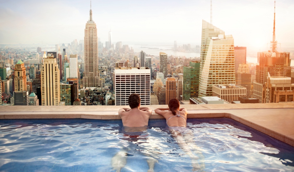 Couple relaxing in swimming pool on hotel rooftop