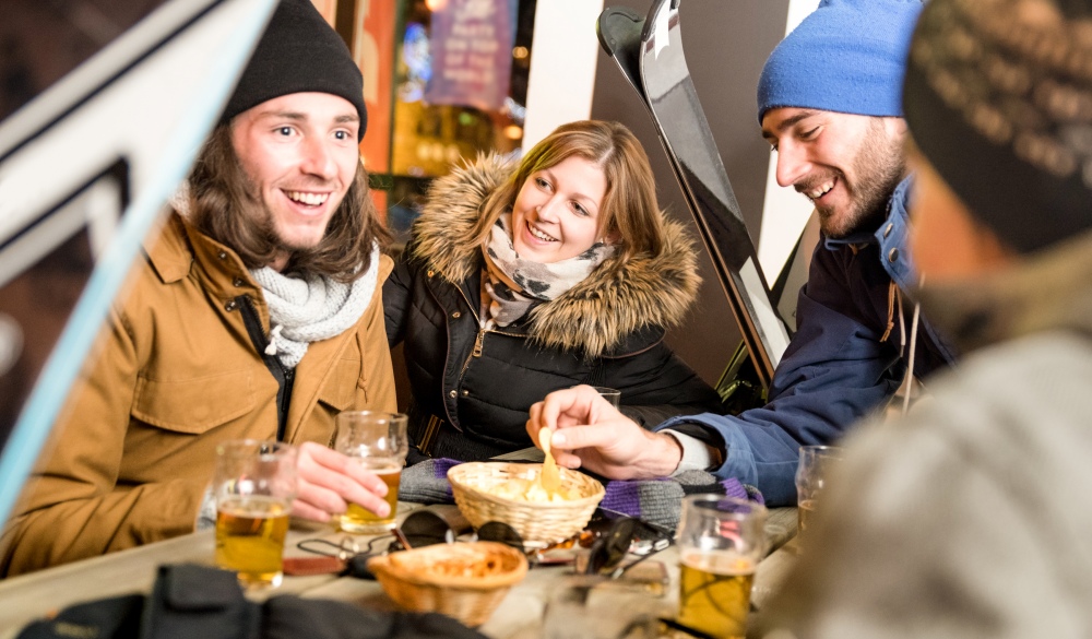 Happy friends drinking beer and eating chips, Whistler-blackcomb holiday